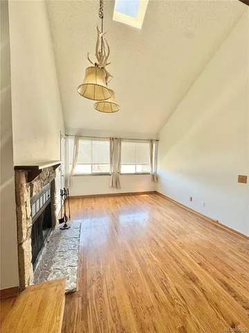 a view of empty room with wooden floor and fireplace