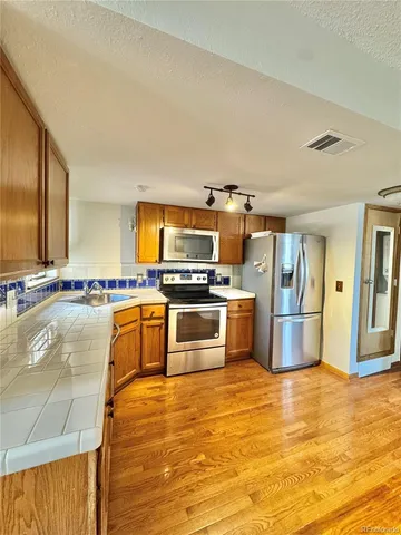 a kitchen with stainless steel appliances kitchen island granite countertop a stove and a sink