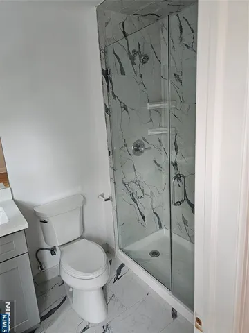a bathroom with a shower a toilet and a sink