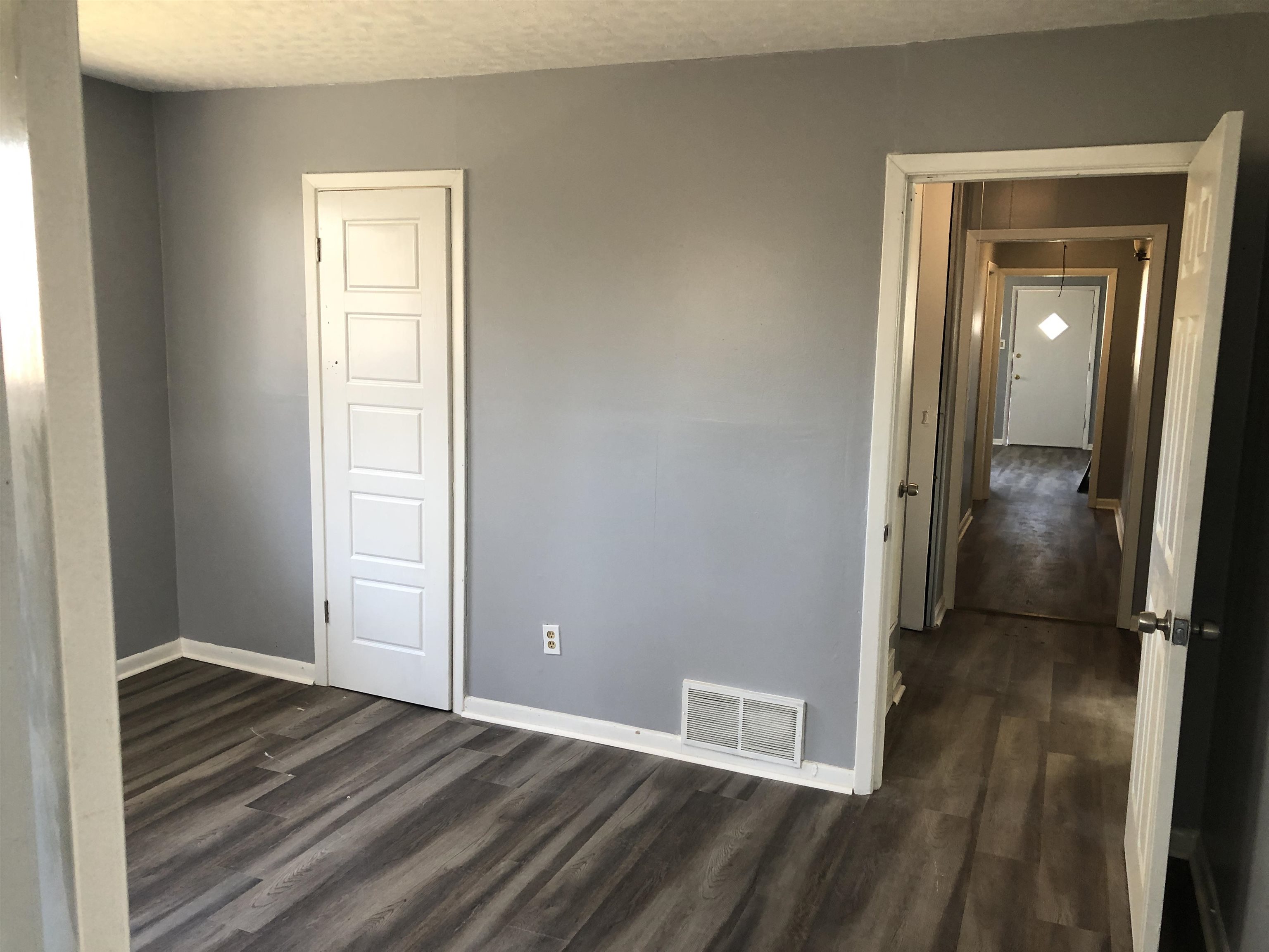 3077 Green Road Memphis, TN 38109 - Photo 8 of 18 an empty room with wooden floor mirror and windows