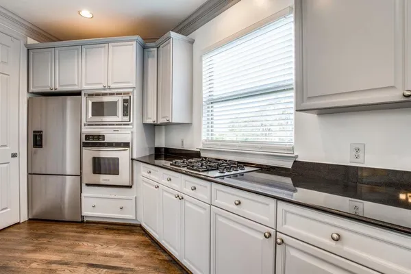 a kitchen with granite countertop wooden cabinets and stainless steel appliances