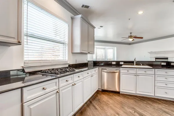 a kitchen with a sink white cabinets and white appliances