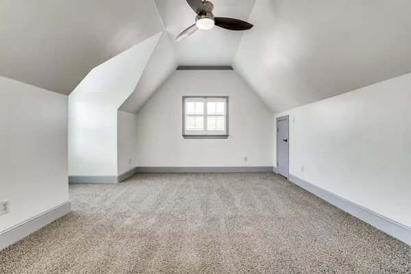 a view of a big room with window and ceiling fan