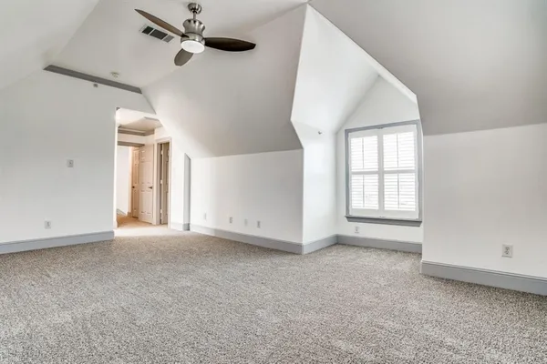 an empty room with windows and ceiling fan