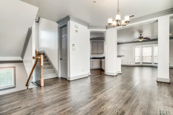 a view of a room with wooden floor staircase and a kitchen