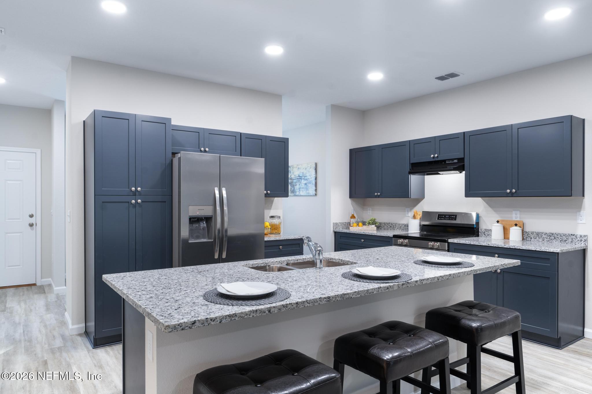 7581 Dove Road Jacksonville, FL 32219 - Photo 12 of 32 a kitchen with stainless steel appliances granite countertop a sink refrigerator and cabinets