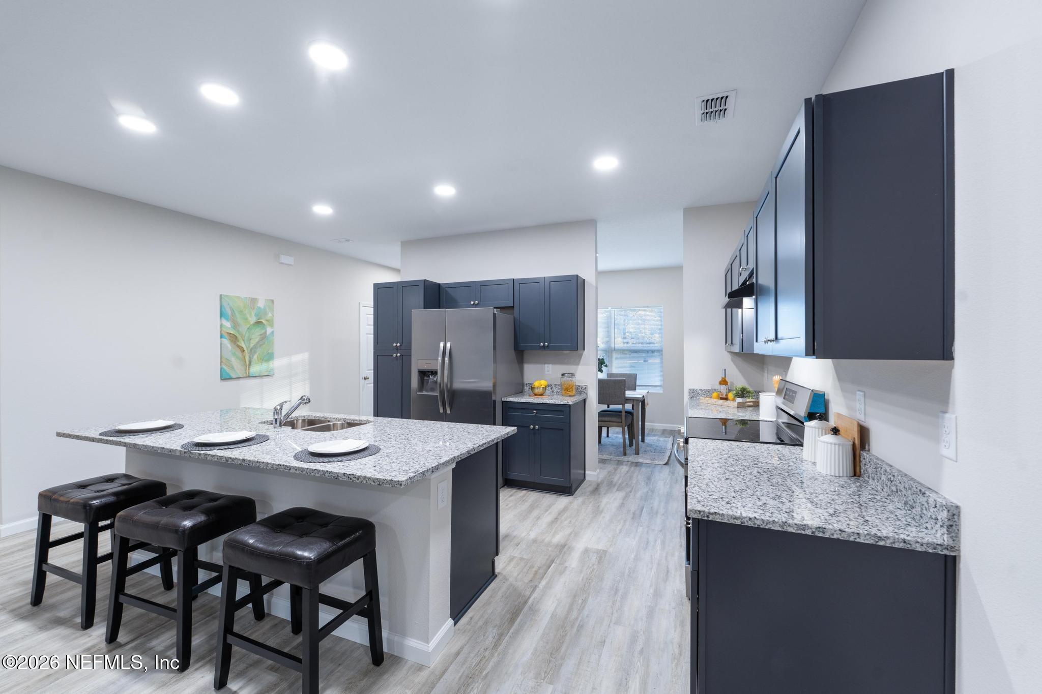 7581 Dove Road Jacksonville, FL 32219 - Photo 15 of 32 a kitchen with refrigerator and cabinets