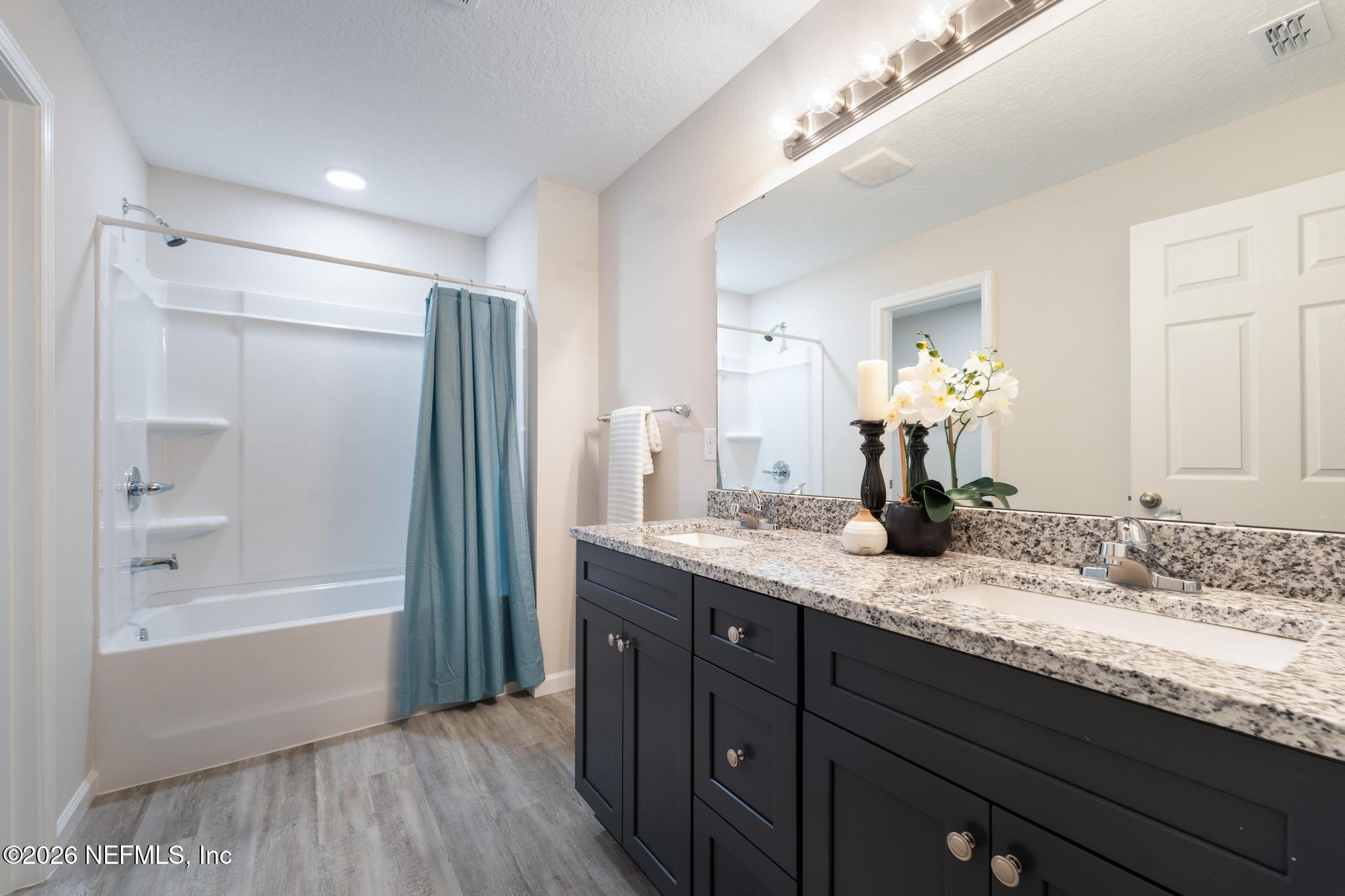 7581 Dove Road Jacksonville, FL 32219 - Photo 23 of 32 a bathroom with a granite countertop sink mirror and a bath tub