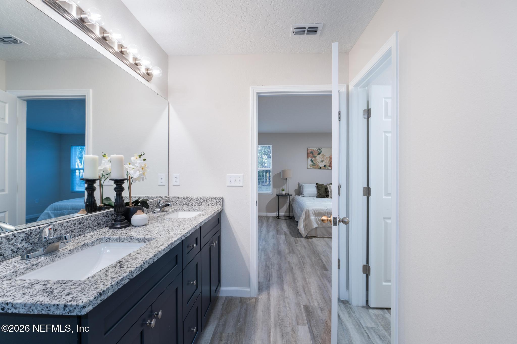 7581 Dove Road Jacksonville, FL 32219 - Photo 24 of 32 a bathroom with a granite countertop sink a toilet and a mirror