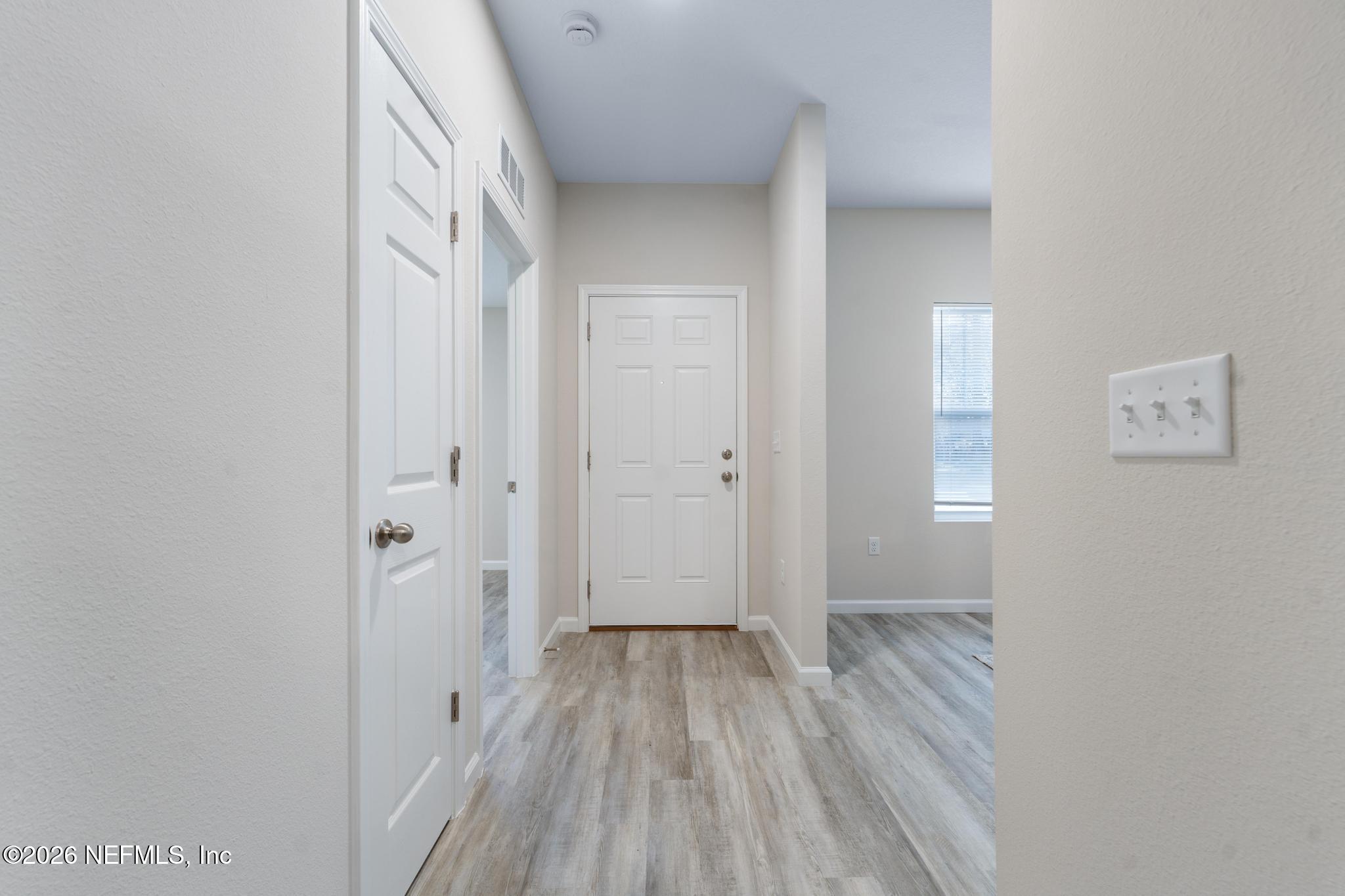 7581 Dove Road Jacksonville, FL 32219 - Photo 5 of 32 a view of a hallway with wooden floor and a bathroom