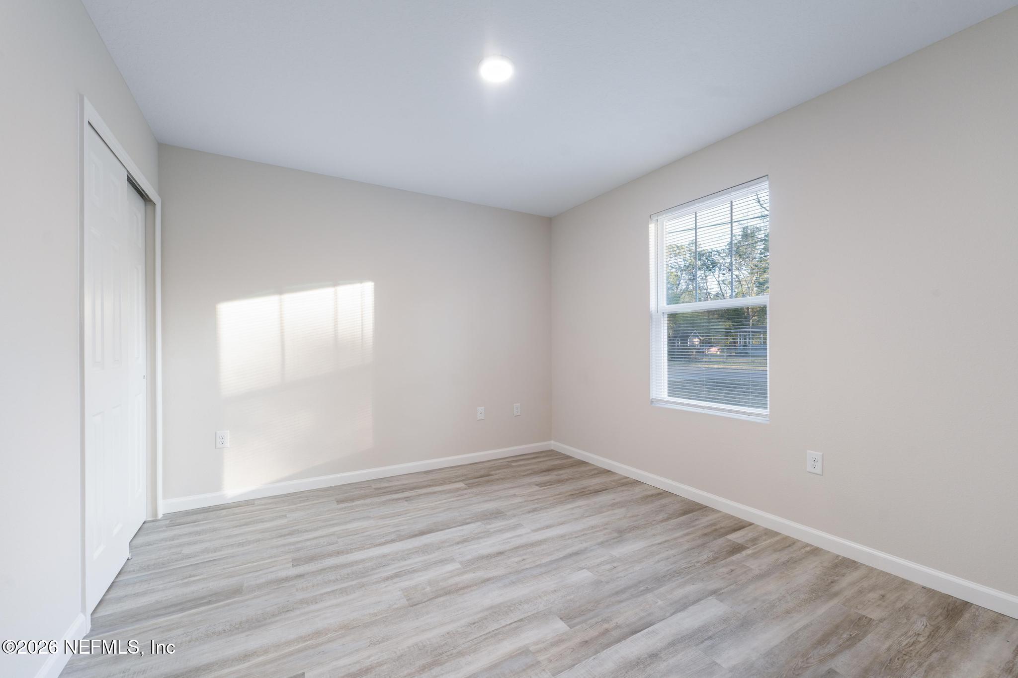 7581 Dove Road Jacksonville, FL 32219 - Photo 7 of 32 an empty room with wooden floor and windows