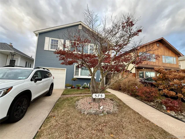 a front view of a house with parking yard and parking space