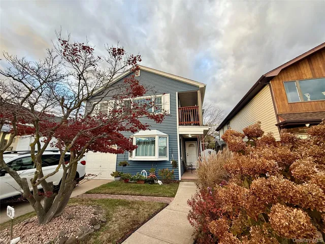 a view of a house with a tree in front of it
