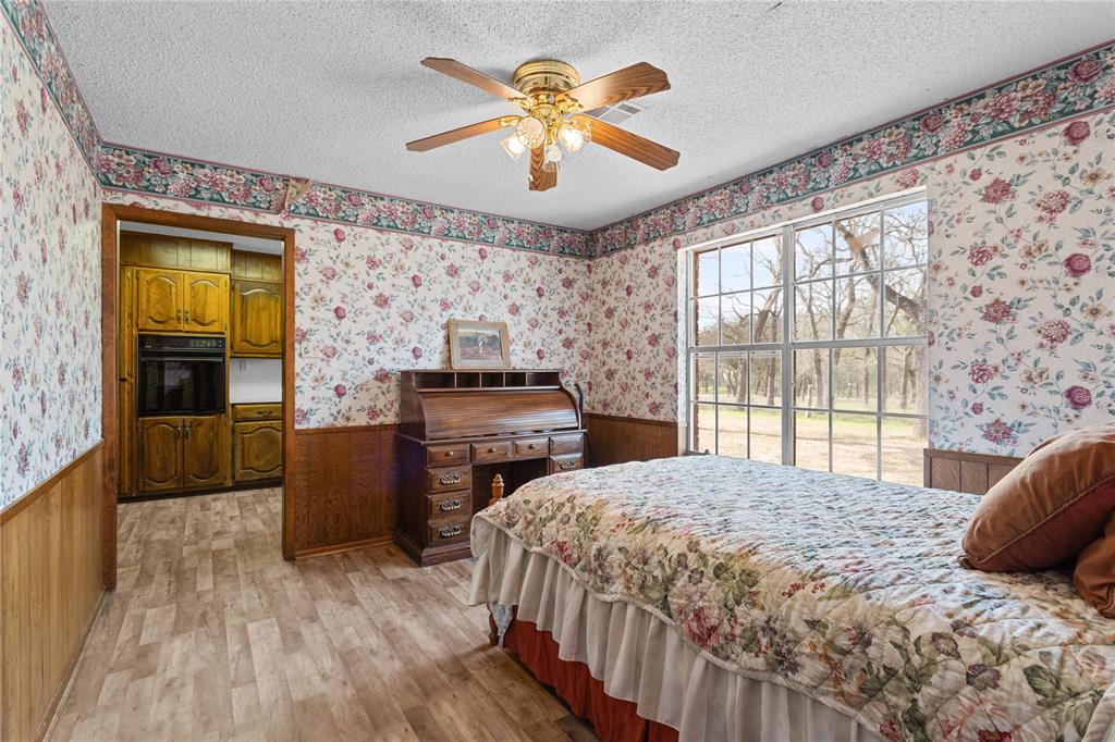 1447 Red Gate Road Mart, TX 76664 - Photo 28 of 38 a bedroom with a bed and a chandelier