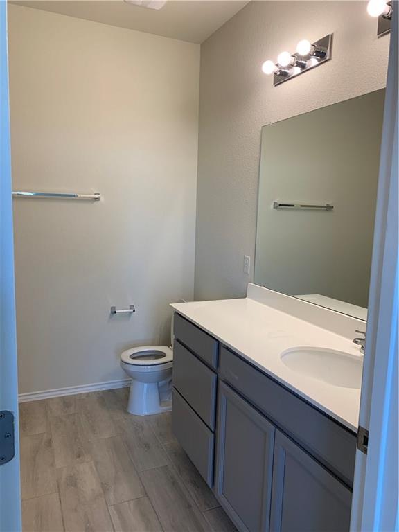 1229 Cliffbrake Way Georgetown, TX 78626 - Photo 10 of 24 a bathroom with a granite countertop sink a toilet and a mirror