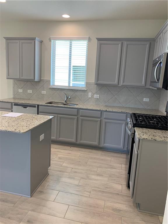 1229 Cliffbrake Way Georgetown, TX 78626 - Photo 5 of 24 a kitchen with a sink stove and cabinets