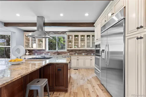 a kitchen with granite countertop a stove and a wooden floor