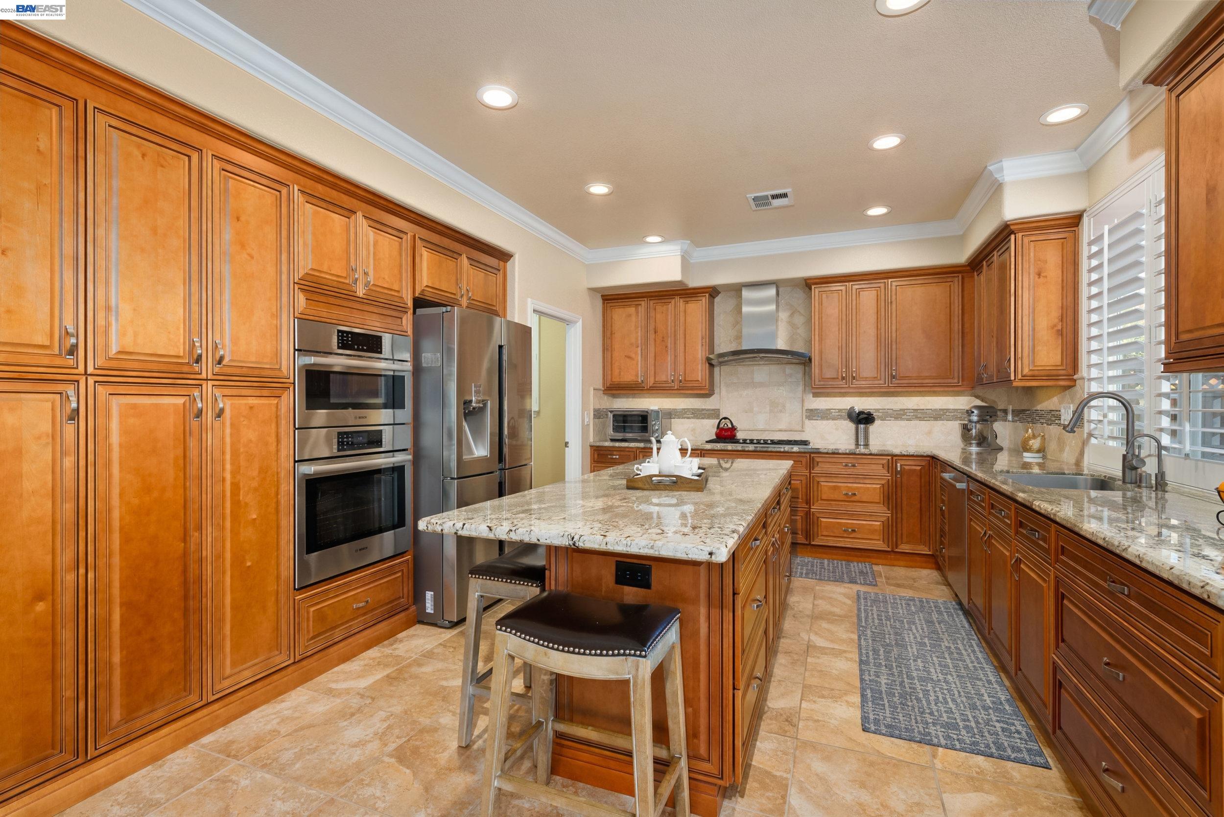 4717 Chestnut Court Dublin, CA 94568 - Photo 15 of 60 a large kitchen with granite countertop a large counter top stainless steel appliances and cabinets