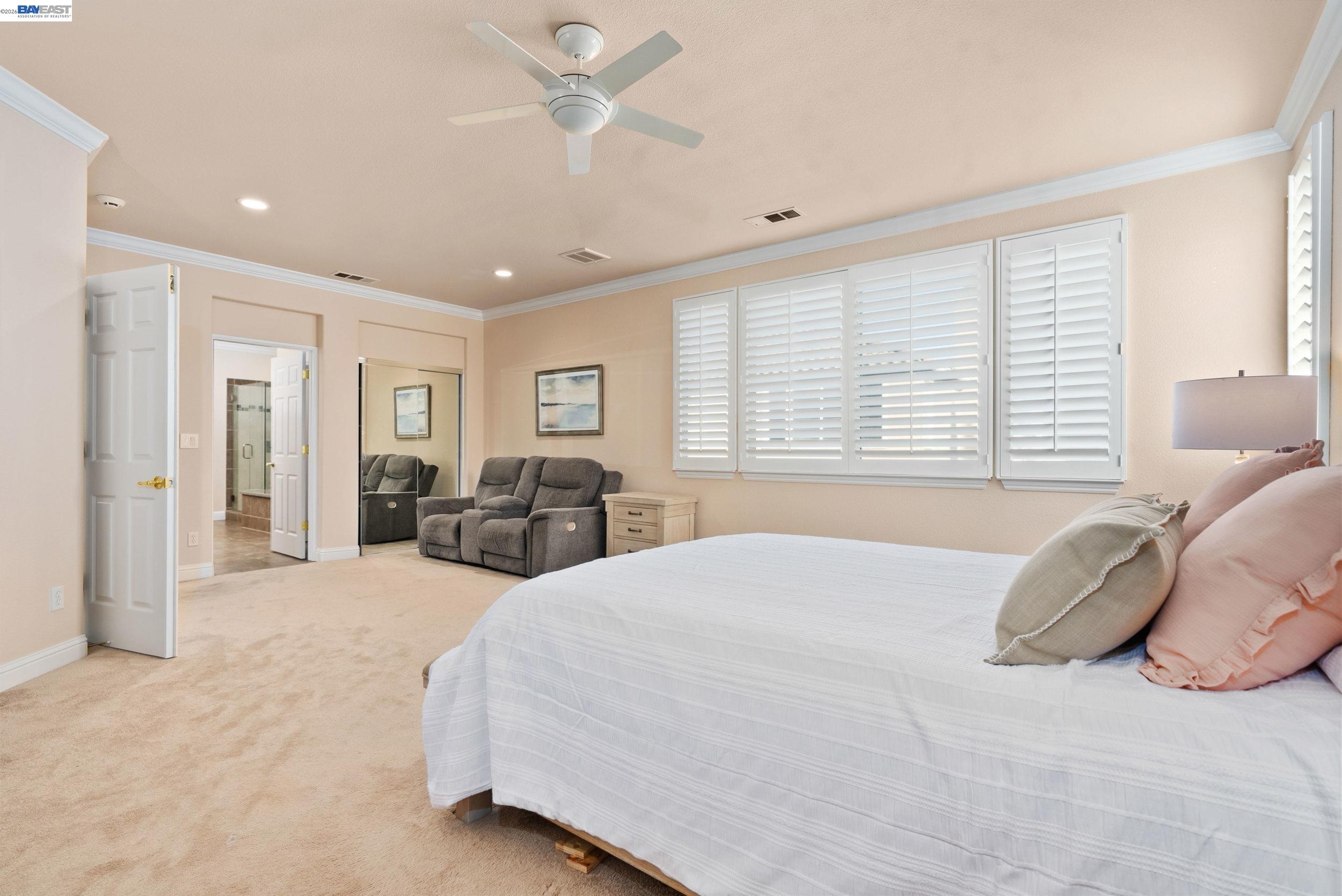 4717 Chestnut Court Dublin, CA 94568 - Photo 29 of 60 a spacious bedroom with a large bed and a chandelier