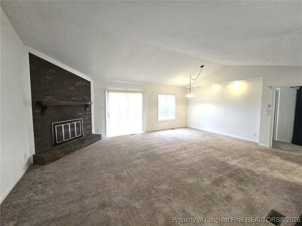 a view of empty room with a fireplace