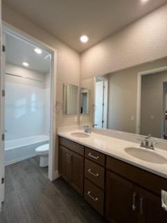 11501 Lagarto Way Rancho Cordova, CA 95742 - Photo 6 of 10 a bathroom with a granite countertop sink toilet a large mirror a bathtub and shower