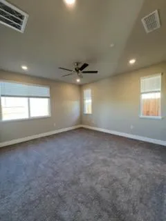an empty room with a window and a ceiling fan