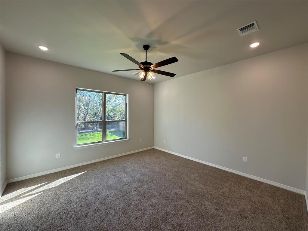 133 Lasso Loop Lorena, TX 76655 - Photo 12 of 22 an empty room with windows and ceiling fan