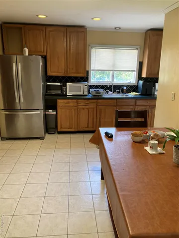 a kitchen with kitchen island granite countertop a stove a sink and a refrigerator