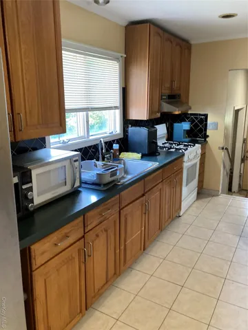 a kitchen with stainless steel appliances a sink cabinets and a window