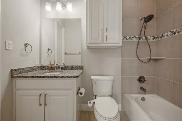 a bathroom with a granite countertop toilet sink and shower