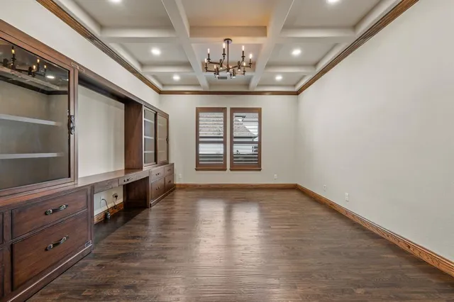 a view of an empty room with cabinet and wooden floor