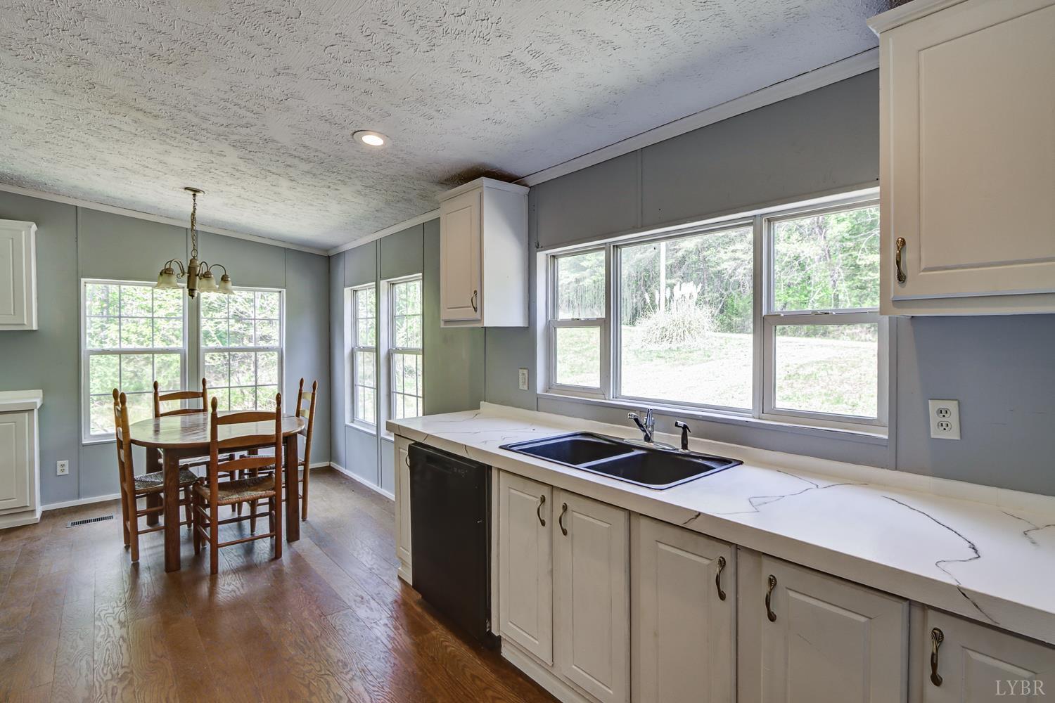 102 Slow Water Court Sandy Level, VA 24161 - Photo 15 of 66 a kitchen with stainless steel appliances granite countertop sink stove and dining table chairs
