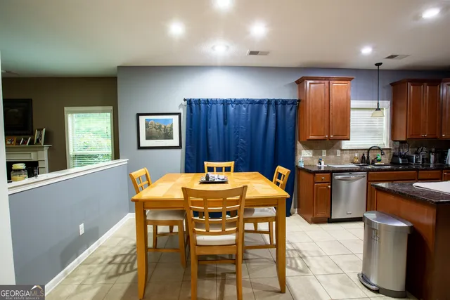 a kitchen with a table chairs sink and refrigerator