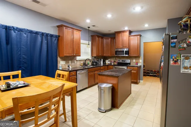 a kitchen with stainless steel appliances wooden cabinets a stove top oven a sink and dishwasher