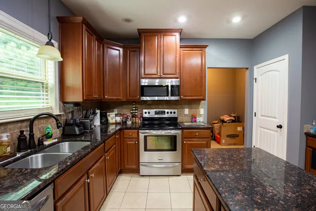 a kitchen with stainless steel appliances granite countertop a stove sink and cabinets