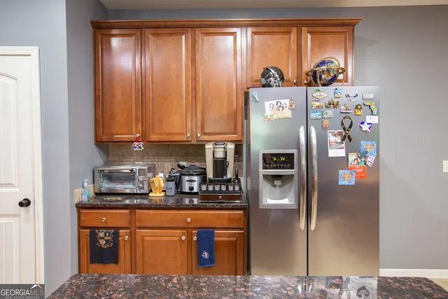 a kitchen with stainless steel appliances granite countertop a refrigerator and a stove