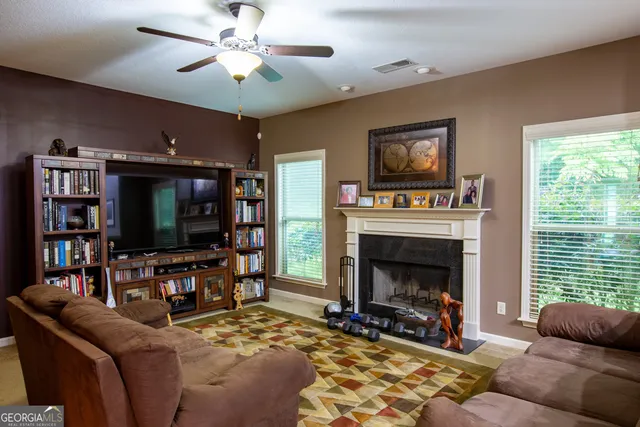 a living room with furniture a flat screen tv and a fireplace
