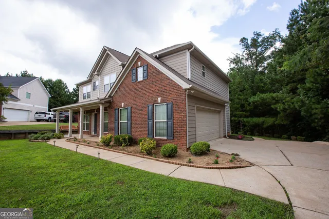 a front view of a house with a yard and potted plants