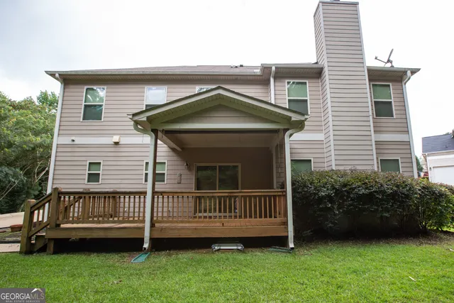 a view of a house with a deck and backyard