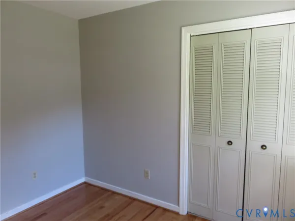 an empty room with wooden floor and closet