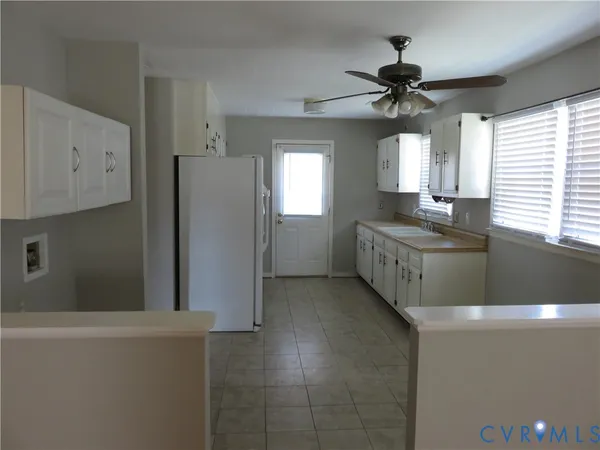 a kitchen with stainless steel appliances a sink a refrigerator and window