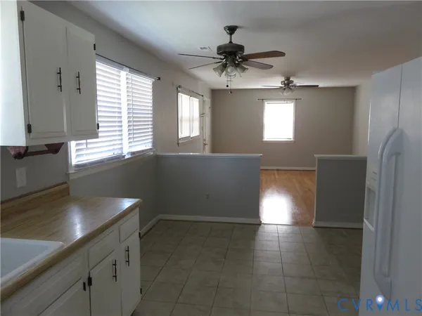 a view of a kitchen with refrigerator and window