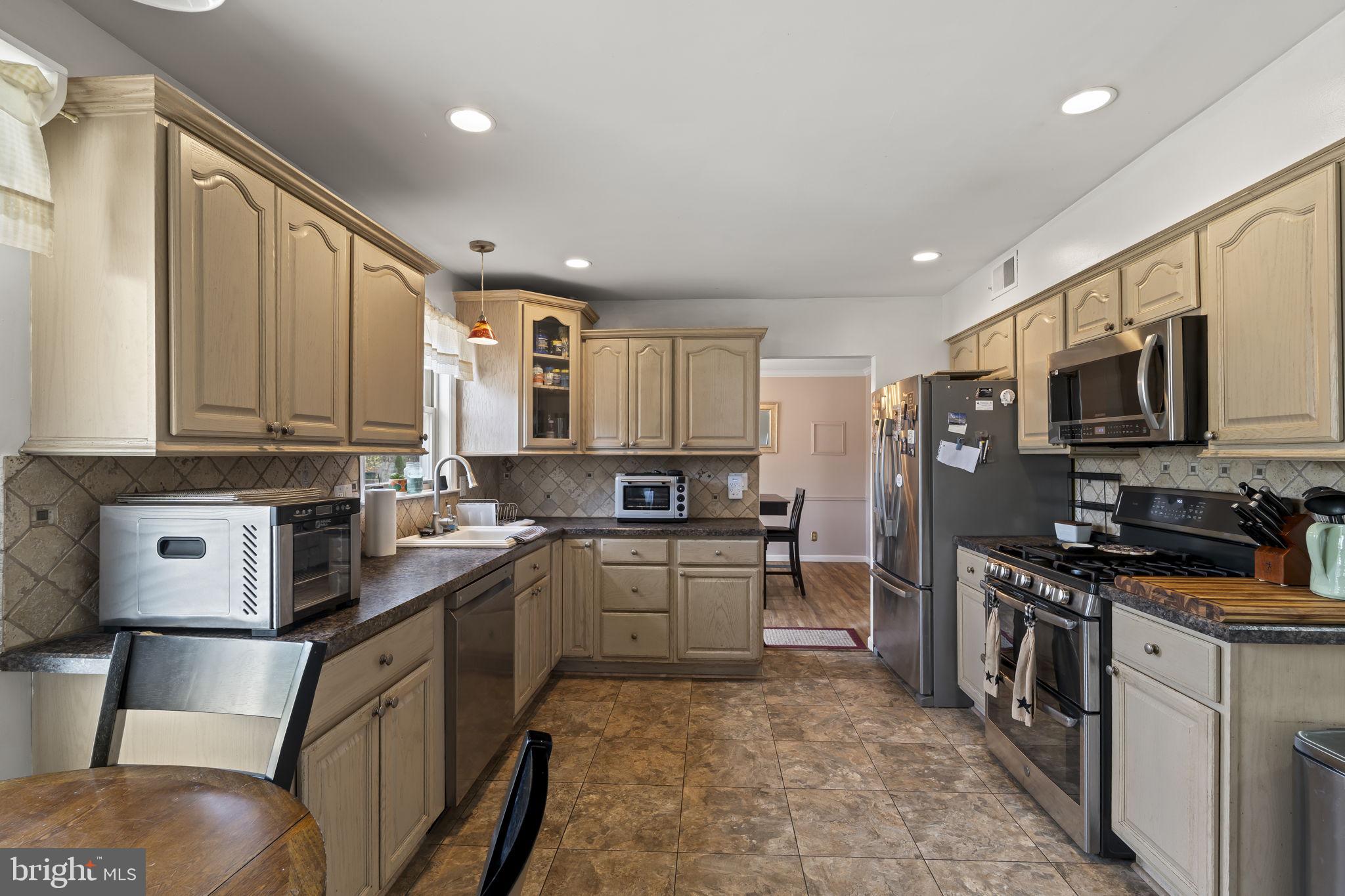 4 Margy Lane Marlton, NJ 08053 - Photo 16 of 46 a kitchen with stainless steel appliances granite countertop a sink stove microwave and refrigerator