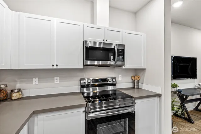 a kitchen with stainless steel appliances a stove a sink and a microwave