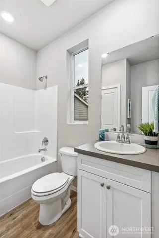 a bathroom with a toilet a sink a tub and mirror