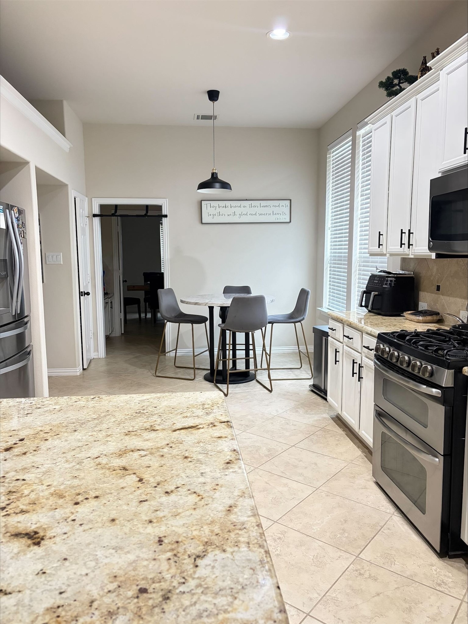 3042 Currant Drive Manvel, TX 77578 - Photo 7 of 12 a large kitchen with kitchen island a stove a sink dishwasher and white cabinets with wooden floor
