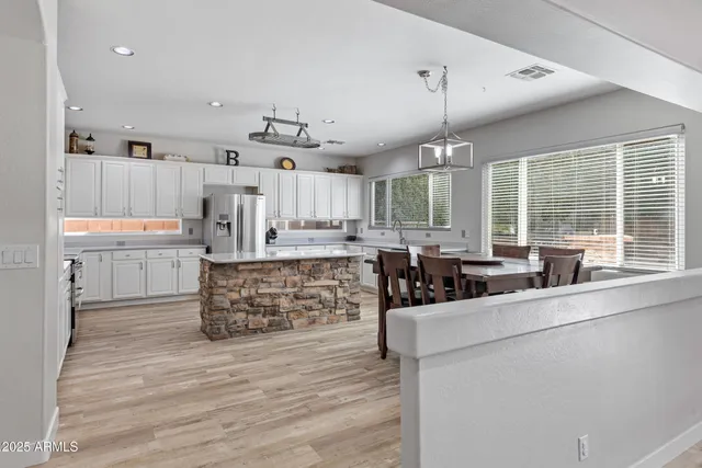 a kitchen with stainless steel appliances a table chairs and a refrigerator