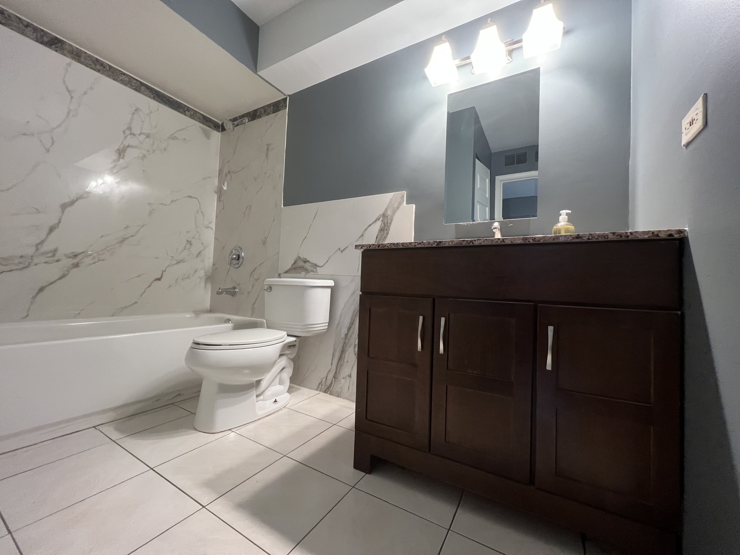 1111 Pleasant Run Drive, Unit 902 Wheeling, IL 60090 - Photo 7 of 7 a bathroom with a toilet sink and mirror