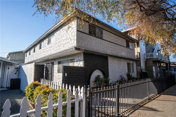 a front view of house yard with wooden fence