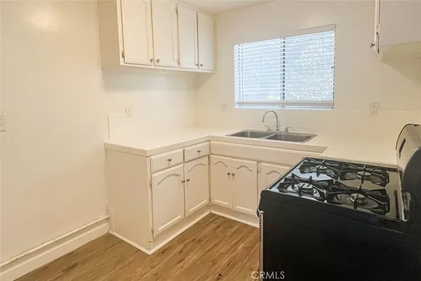 a kitchen with granite countertop white cabinets and black appliances
